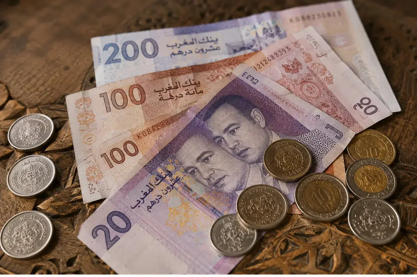 Moroccan dirham banknotes and coins on a wooden surface
